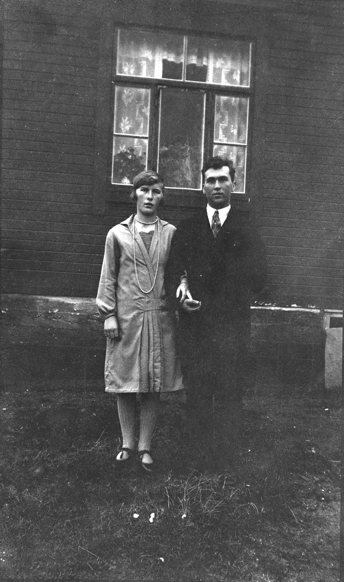 Portrett av par stående på gårdstun.