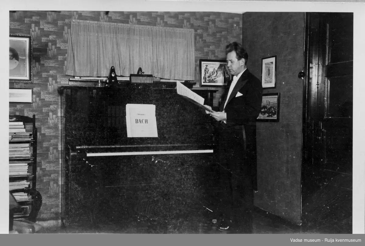 Gottfred Pedersen stående ved pianoet i stua i Amtmannsgt. 7 i Vadsø ca 1938.