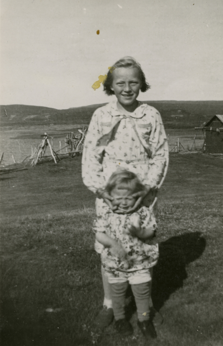 Magnhild Ittelin (g. Reisænen) med lillesøster Agnes Ingeborg utenfor huset til Hulda og Fridtjof Reisænen i Vestre Jakobselv 1940.