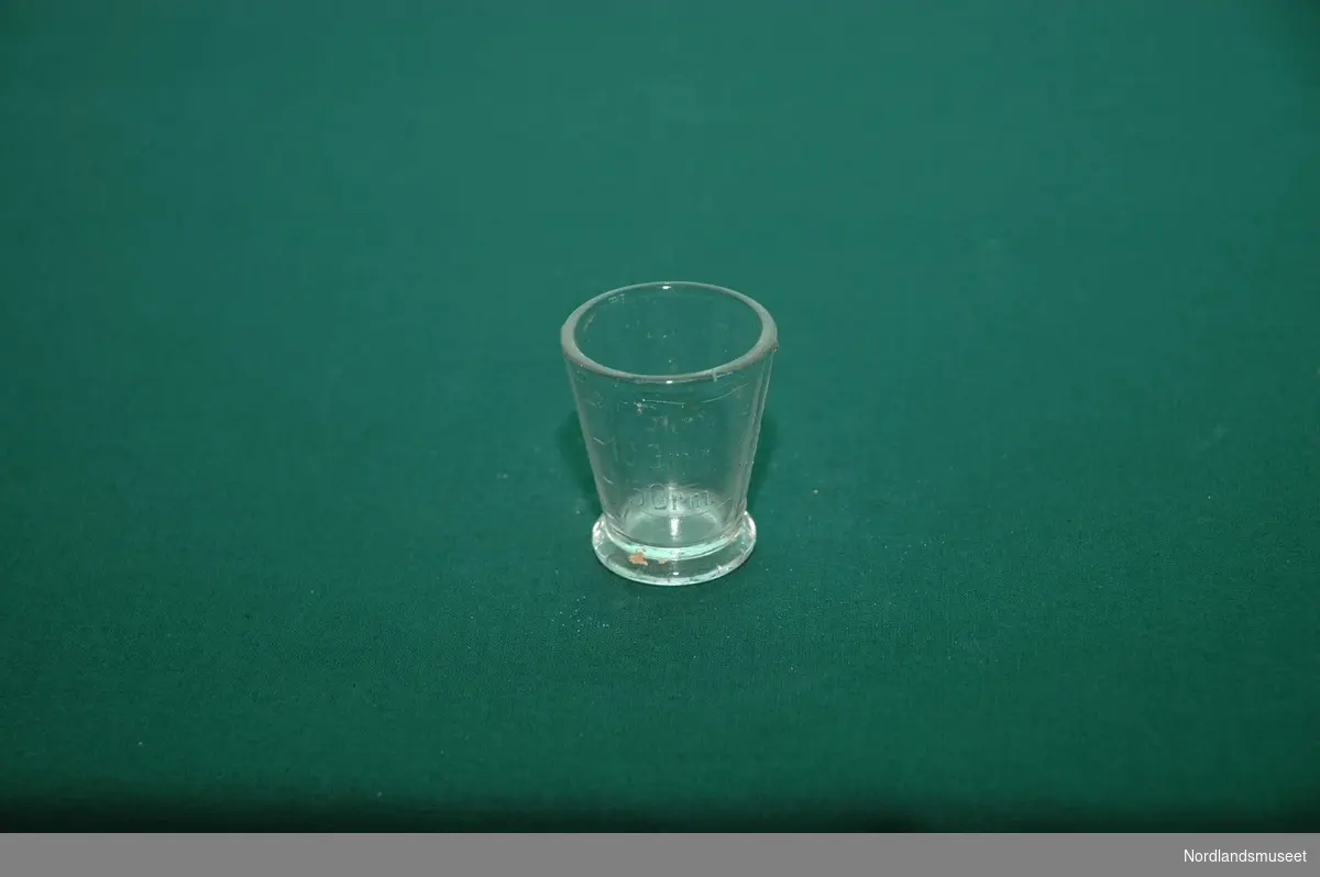Form: Sylinder m/ skrå sider og fotring. Graderinger i glasset.

