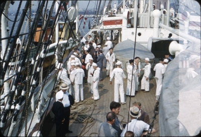 Kadetter og besøkende i dress ombord på dekk på skoleskipet STATSRAAD LEHMKUHL.