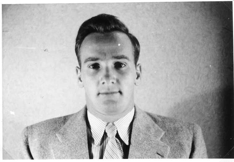 Porträtt av en ung man i kavaj och slips.