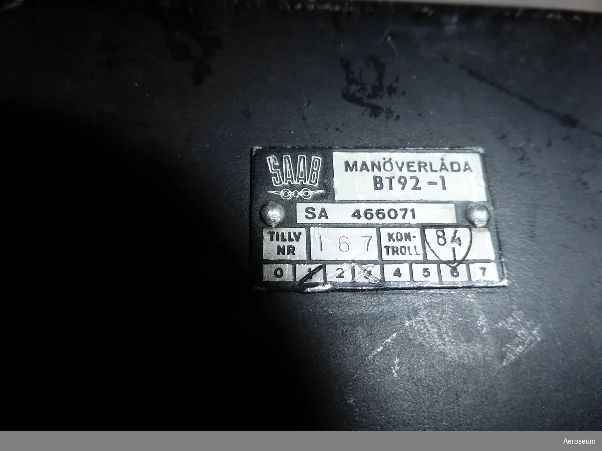 En manöverlåda för J 32 (Lansen). Gjord i svartmålad metall och tillverkad av SAAB.

På en liten platta på ena sidan står det: "MANÖVERLÅDA BT92-1 SA 466071 TILLV NR. 167 KONTROLL 84"
