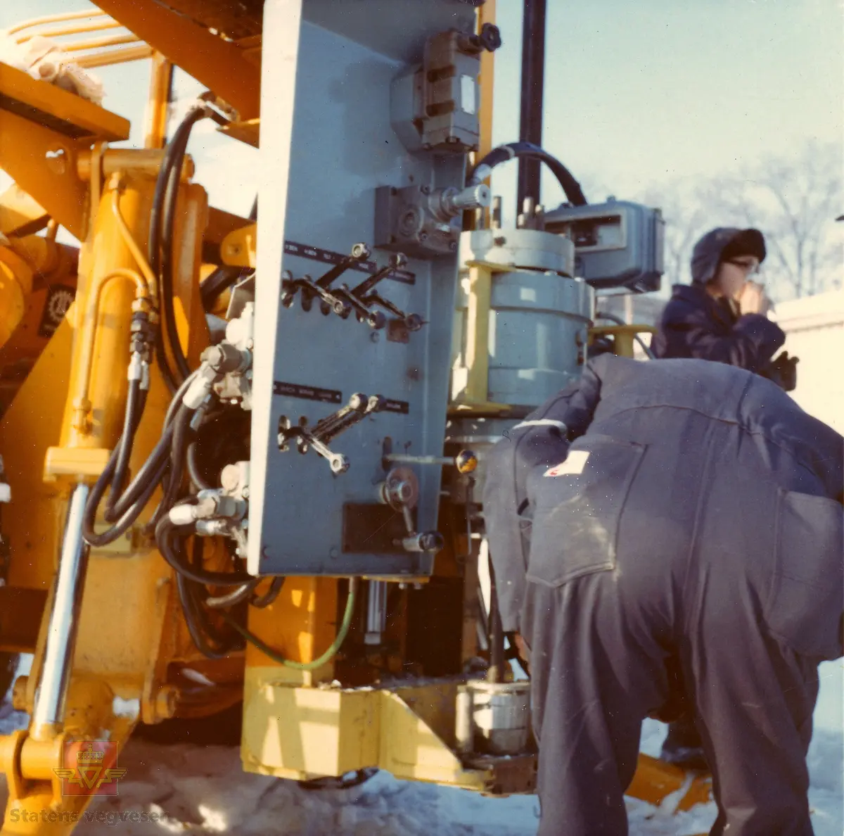 Kurs i bruk av "Hydroriggen" (grunnboringstraktor) utenfor Veglaboratoriet i Oslo februar 1970. 

Utviklingen av “Hydroriggen”på slutten av 1960-t revolusjonerte grunnboringsarbeidet. Det manuelle arbeidet ble redusert, den var lettere å flytte og hadde større kapasitet og evne til nedtrengning. En ny metode kalt dreietrykksondering ble tatt i bruk: Man målte hvor mye kraft som måtte til for å trykke borstengene ned i bakken med konstant hastighet og rotasjon. Riggen kunne også benyttes til andre sonderingsmetoder, prøvetaking og vingeboring. Hydroriggen hadde begrenset framkommelighet tiltross for at den var utstyrt med halvbelter.

 Kilde: Rapport nr: 2550, Teknologiavdelingen SVV: "Grunnboringsutstyr 1960-2000"