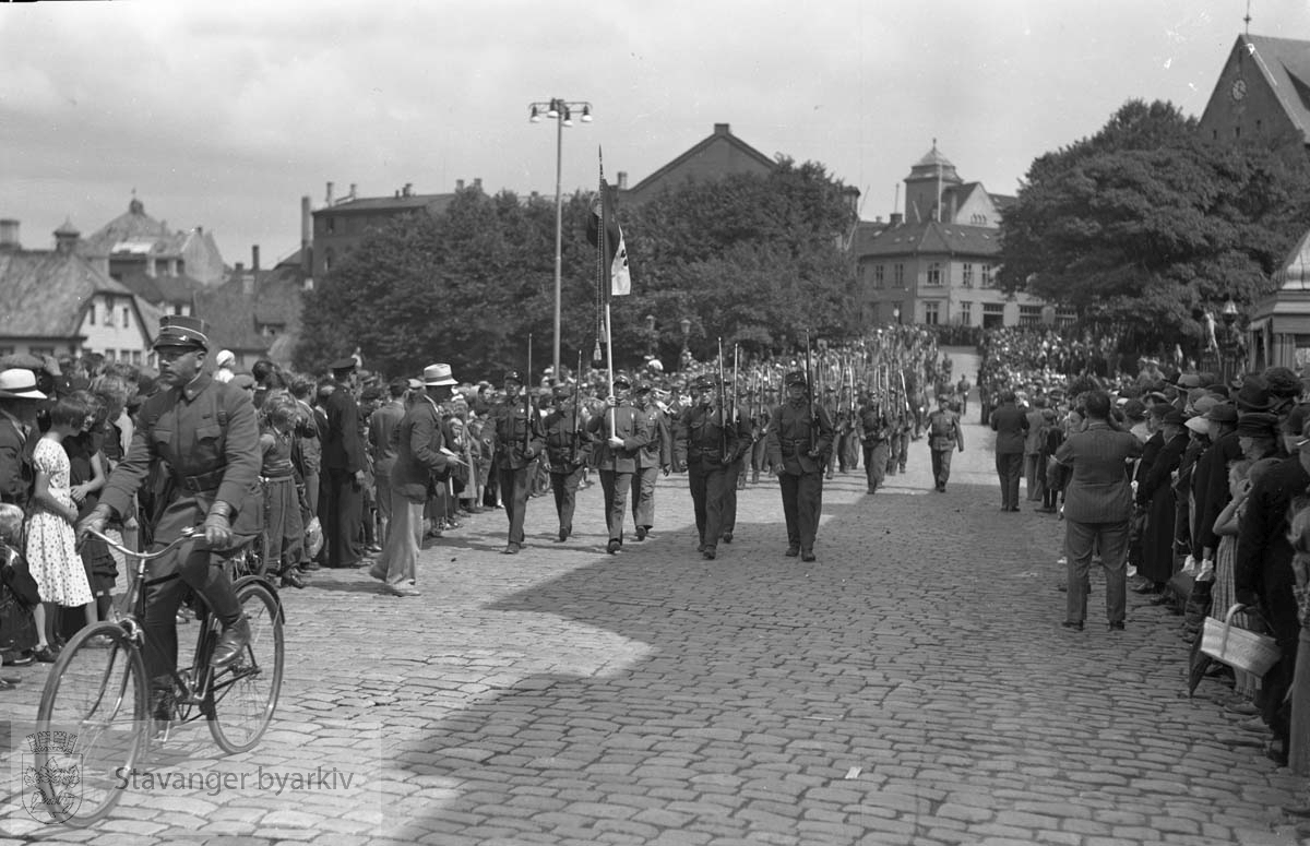 Soldater til fots og sykkel marsjerer foran publikum i Haakon VIIs gate.