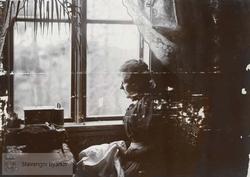 Kvinne med sysaker ved vinduet