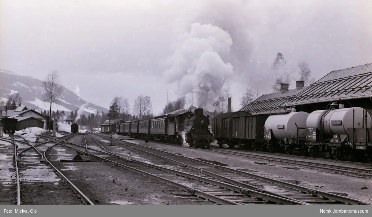 Damplokomotiv type 24b nr. 195 med persontog retning Oslo Ø kjører ut fra Dokka stasjon 2. påskedag 1967.
