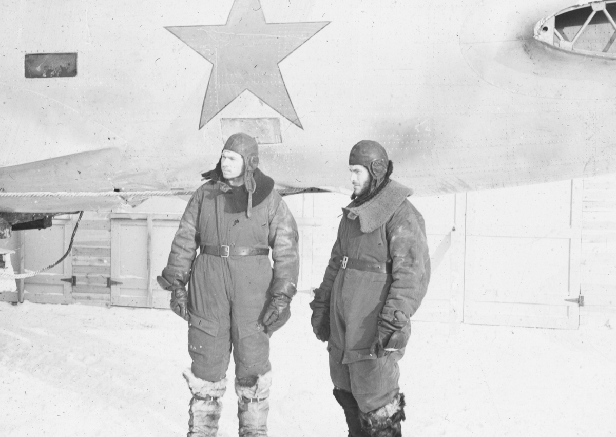 Sovjetiska flygare som tagits som krigsfångar. I bakgrunden det ...