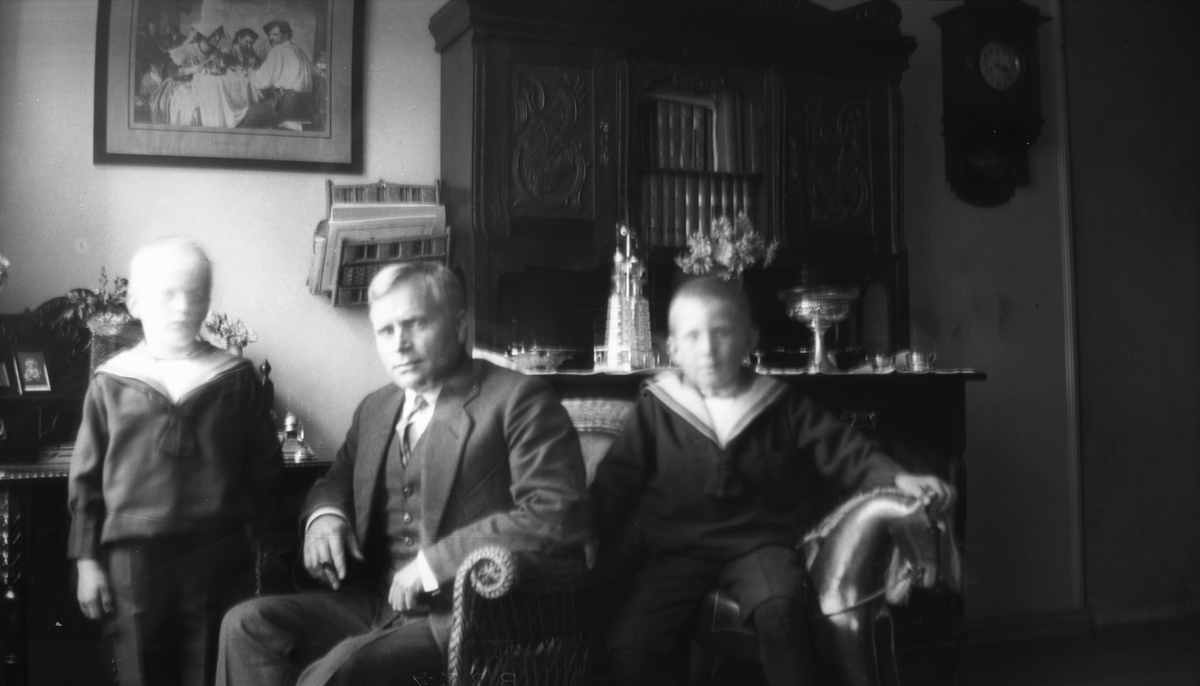 Lærer Vilhelm Hovland i sitt hjem i Tunes vei 9, med sønnene, Finn til venstre og Endre til høyre, ca. 1920.