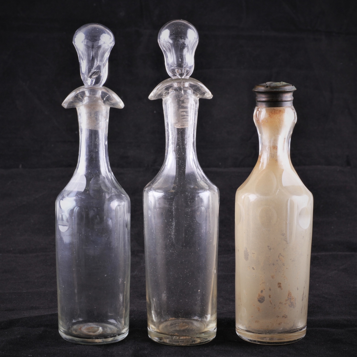 Flasken er slank og har dobbel helletut og glasspropp. Flasken er dekorert med fasettsliping og olivensliping i annenhvert felt øverst på kroppen.