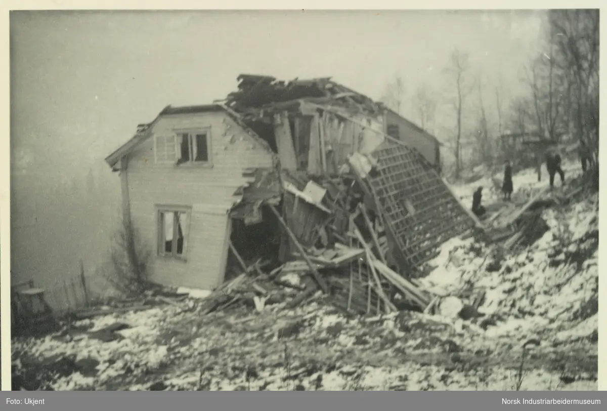 Bolig totalt ødelagt etter bombinga av Vemork i 1943. Taket revet av, mennesker står bak huset