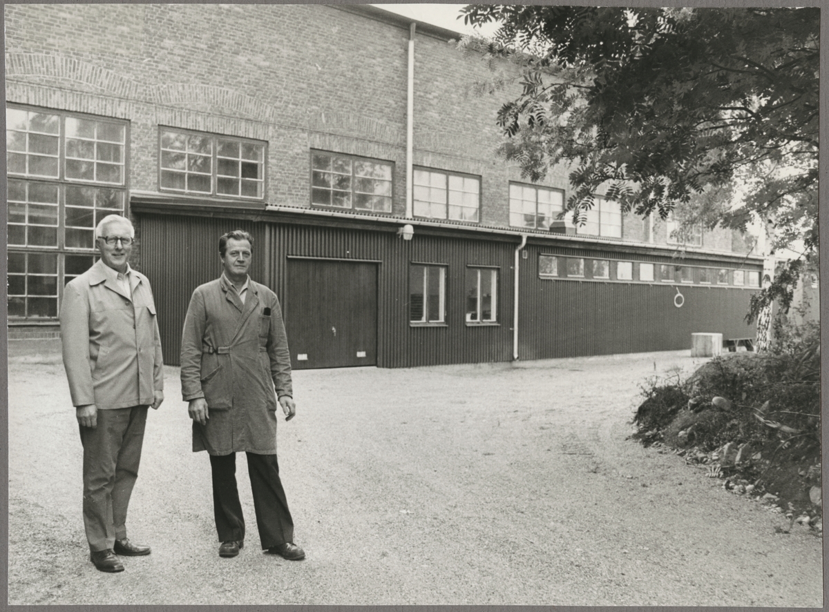Ernst Blixt och Gillis Algelin framför byggnad.