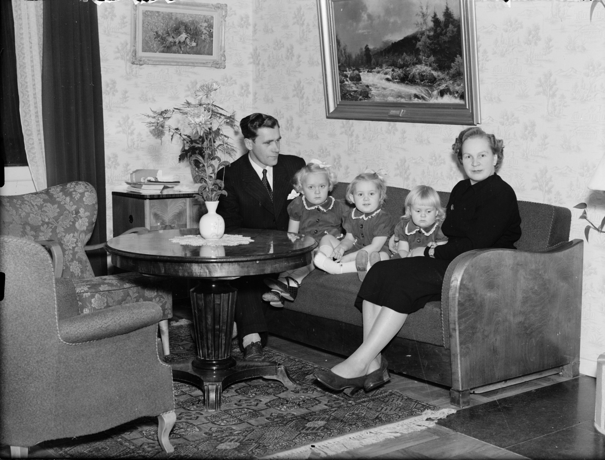 Man, kvinna och tre barn sitter i soffan, Östhammar, Uppland,