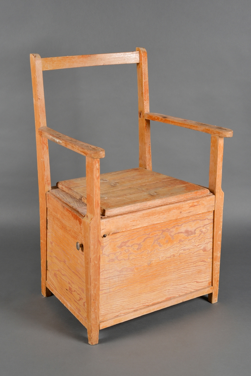En toalettstol med armlener laget av heltre og kryssfinér. Den har sammenføyninger med skruer og lim samt treforbindelser. Både sete og rygg er firkantet på form. Ryggen består kun av en firkantet ramme. Setet har et lokk som kan tas av. Under lokket er setet med et hull i midten. På venstre side er det en dør med dørknott øverst til høyre. Inni stolen kan man plassere potte eller bøtte. Stolen er lakkert utvendig.