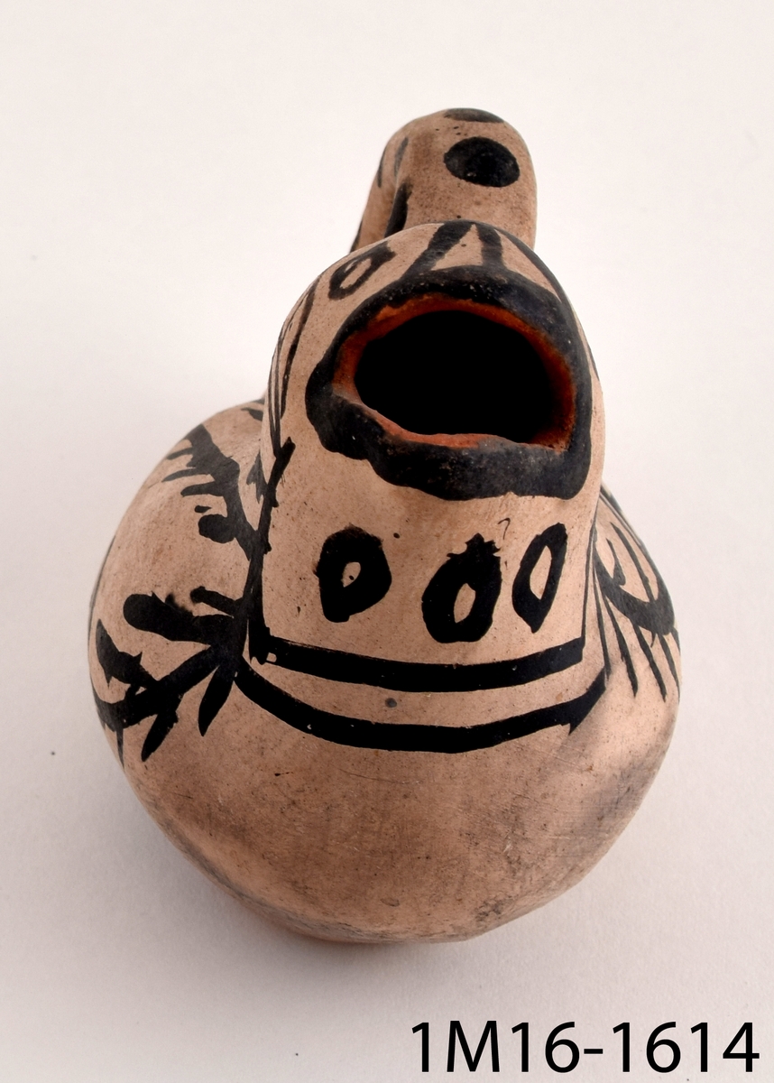 Kanna i form av en keramikfågel som även är utformad som en tillbringare. Fågeln är vitmålad med svart dekor bestående av bland annat prickar och ränder.