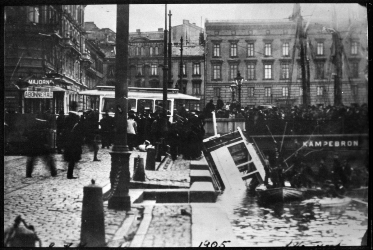 Spårvagnsolycka vid Kämpebron. En spårvagn körde ner i Stora Hamnkanalen i Göteborg efter kollision mellan två spårvagnar, många åskådare på plats.