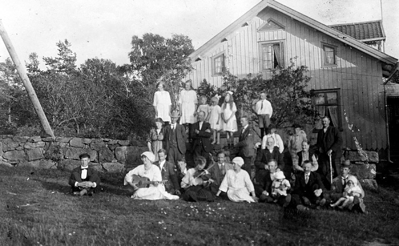 Sommargästerna Blombergs från Göteborg är samlade utomhus, Tulebo Nordgård 1:5 ”Benanders”, "Mattssons" cirka 1920. Några utav dem har instrument.