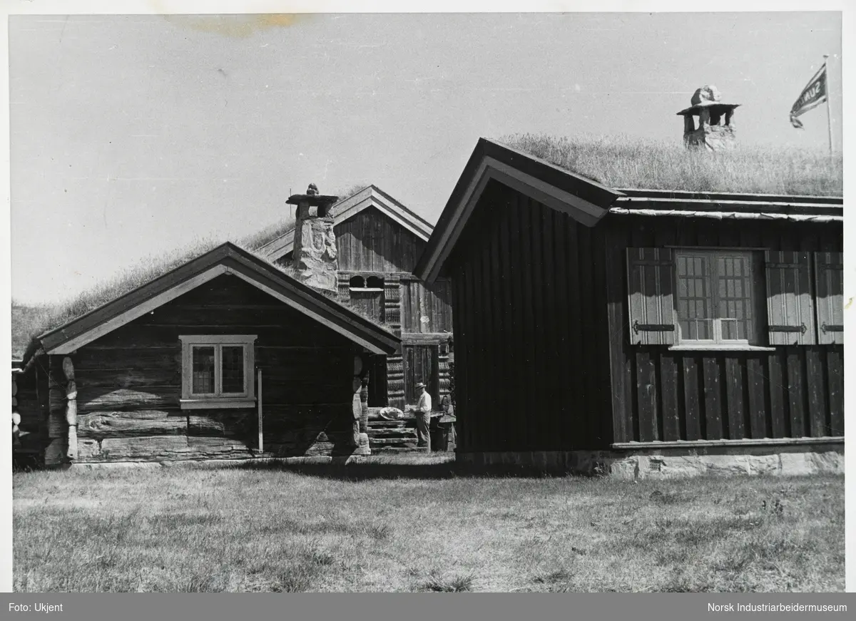 Mann står ved Ellefstjønnburet ved hyttetun sommeren 1955 på Sundet, Møsstrond