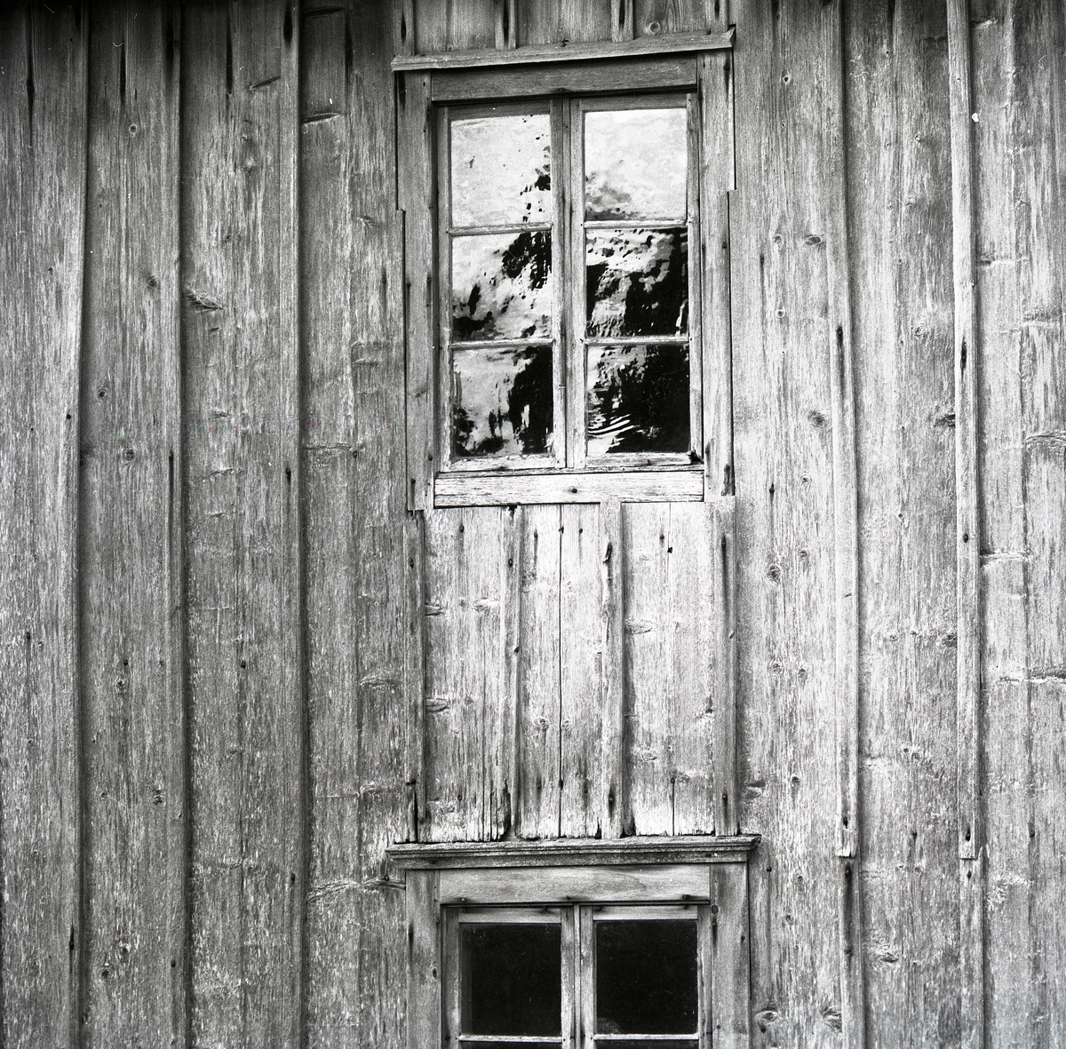 En byggnad i trä med fönster och fönsterkarmar. Utegårn 24 augusti 1990.