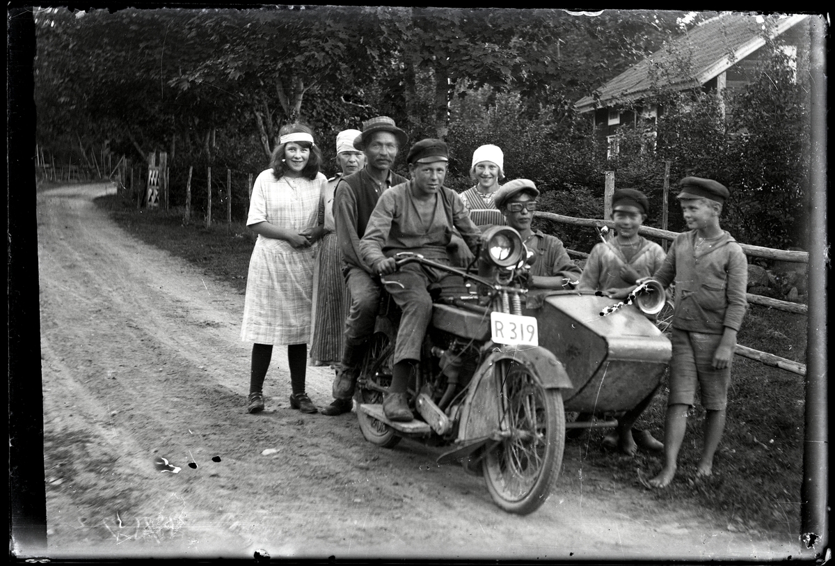 Barn samlade kring man med motorcykel