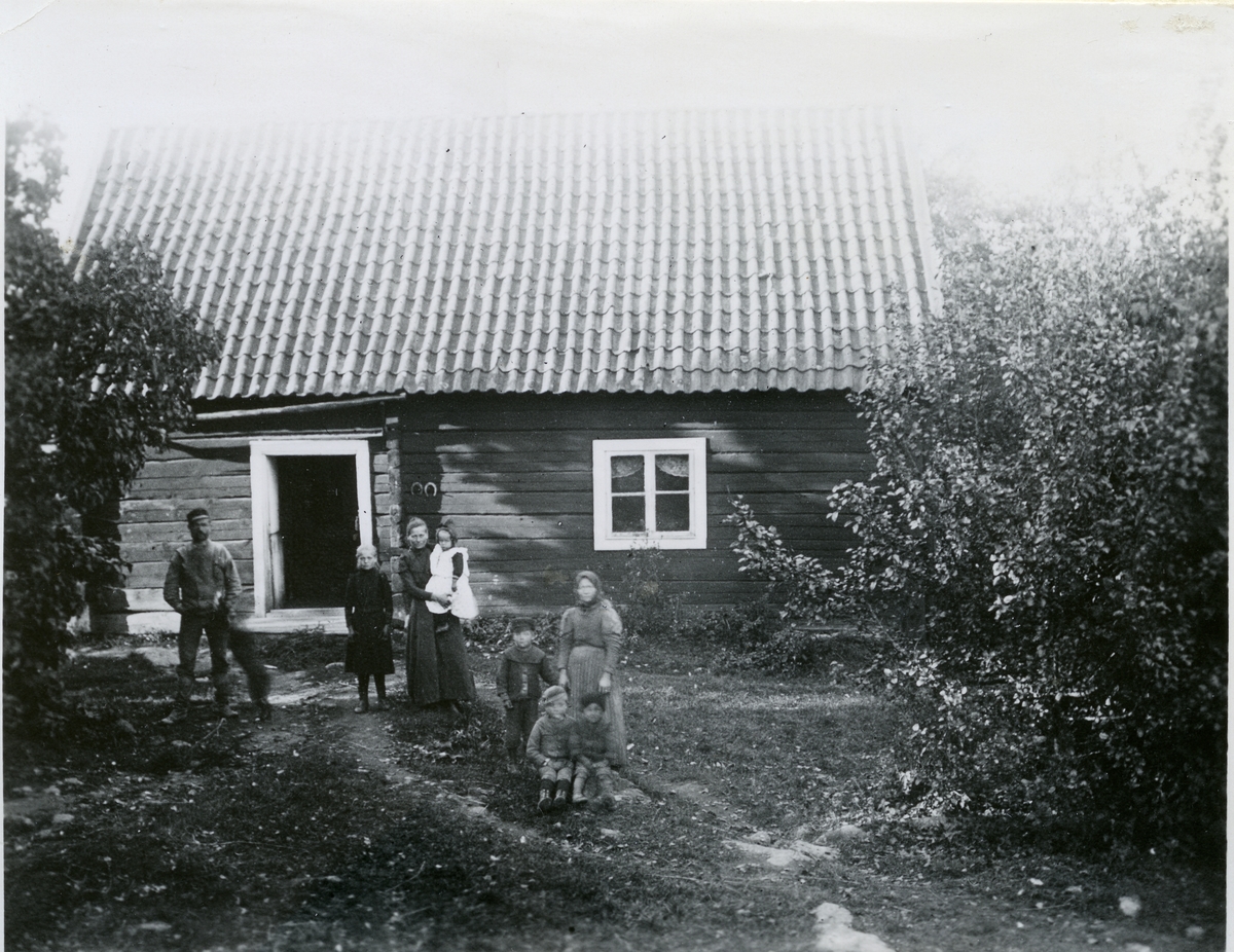Lillhärad sn, Västerås.
Skräddartorp. Familj stående utanför bostaden. 1900-1910.