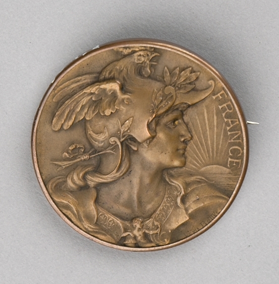 Motiv på forsiden er portrett av mannsperson med helm på hodet og på baksiden er det en kvinnefigur som holder i en ende av en rosenkrans som omgir en sirkelplate med påskrift og datering.