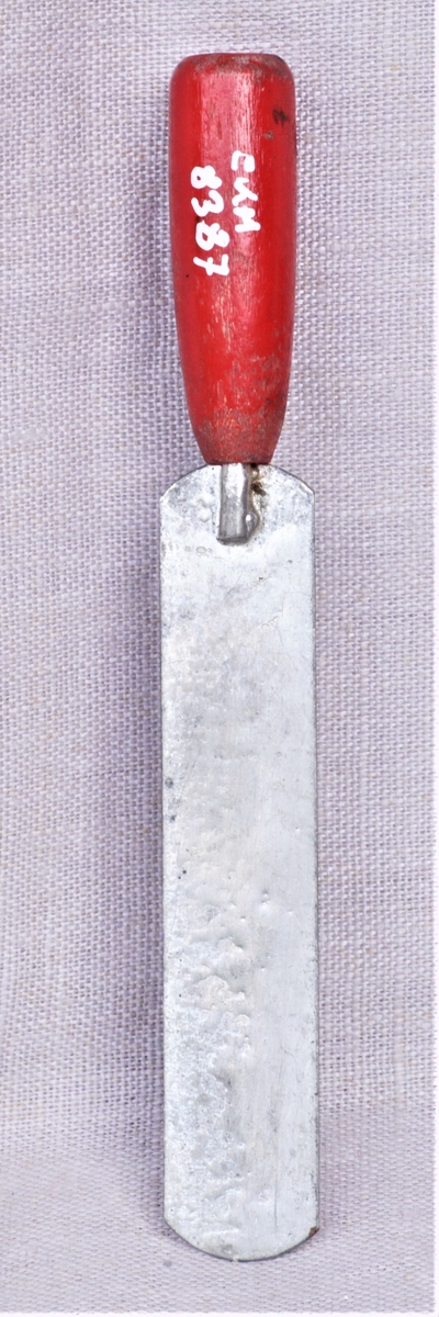 Lekesmørkniv av metall med rødt treskaft.