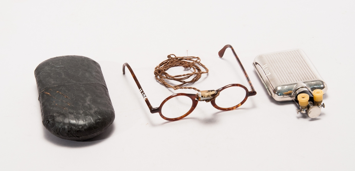 Glasögon med belysning, för läkare i fodral och med batteribehållare av metall.