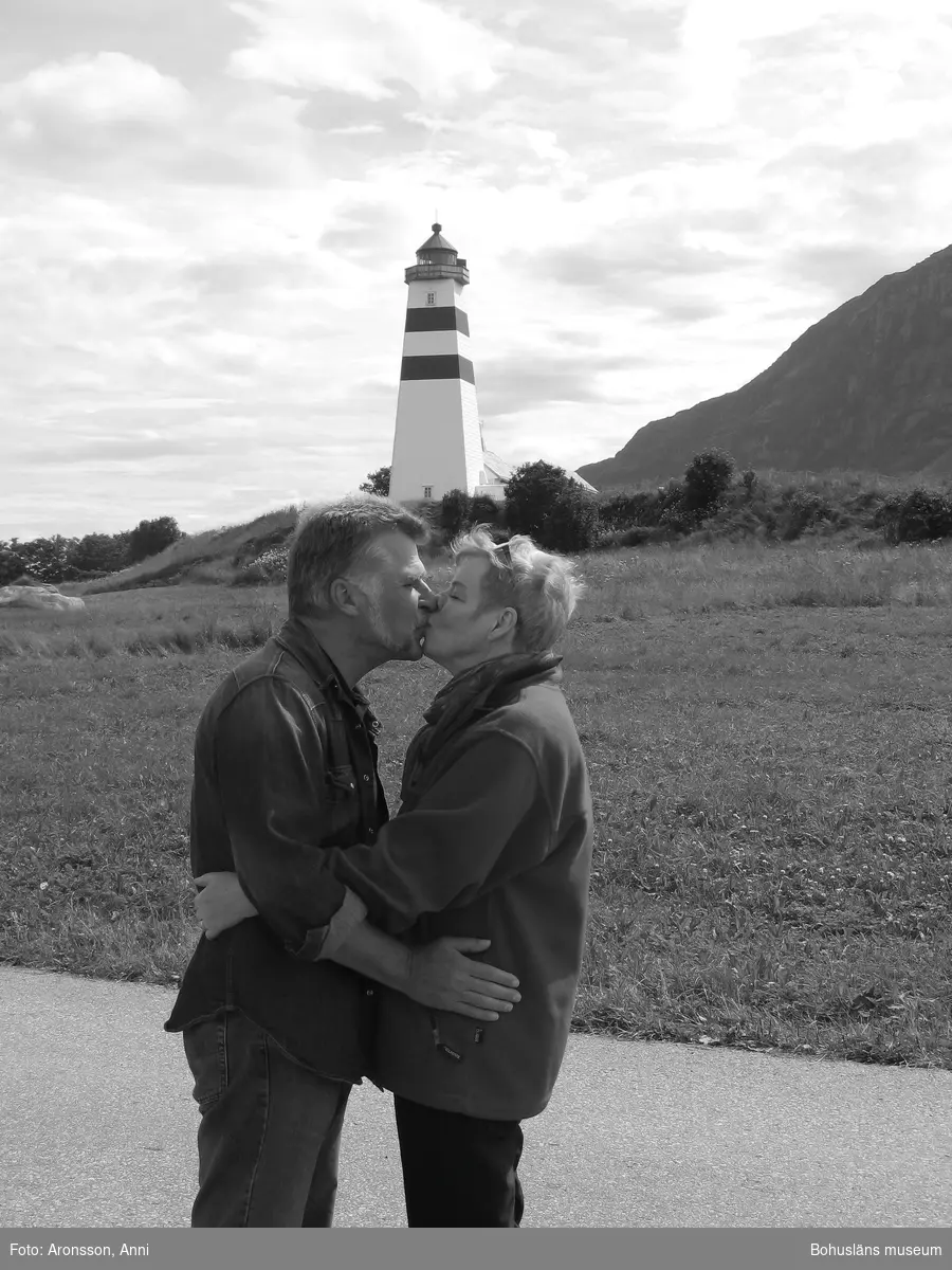 Anni och Kjell kysser varandra ståendes framför en fyr