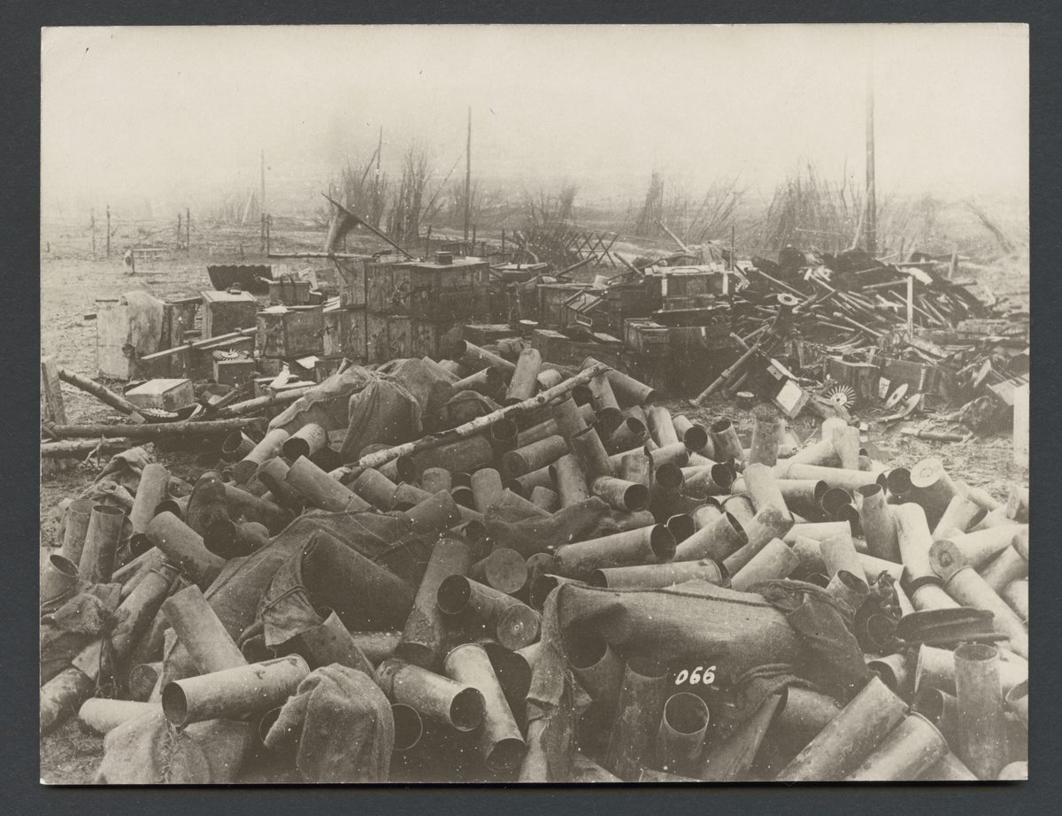 Bilden visar en hög krigsmateriel som består av tomma ammunitionshylsor, ammunitionslådor och skrot.

Originaltext: "Av tyskarna på vägen till Ypern erövrade engelska pionierupplag."