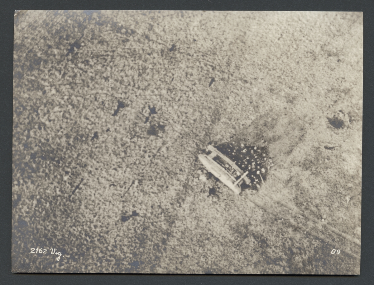 Denna flygbild visar en grupp människor som samlas bakom en stridsvagn. Men det är betydlig fler en de åtta soldater som fanns på en tankbesättning.

Originaltext: "Besättningen i en av tyskt artilleri sönderskjuten engelsk tank, som för en tysk flygares kulspruteeld sökt betäckning bakom pansartanken."