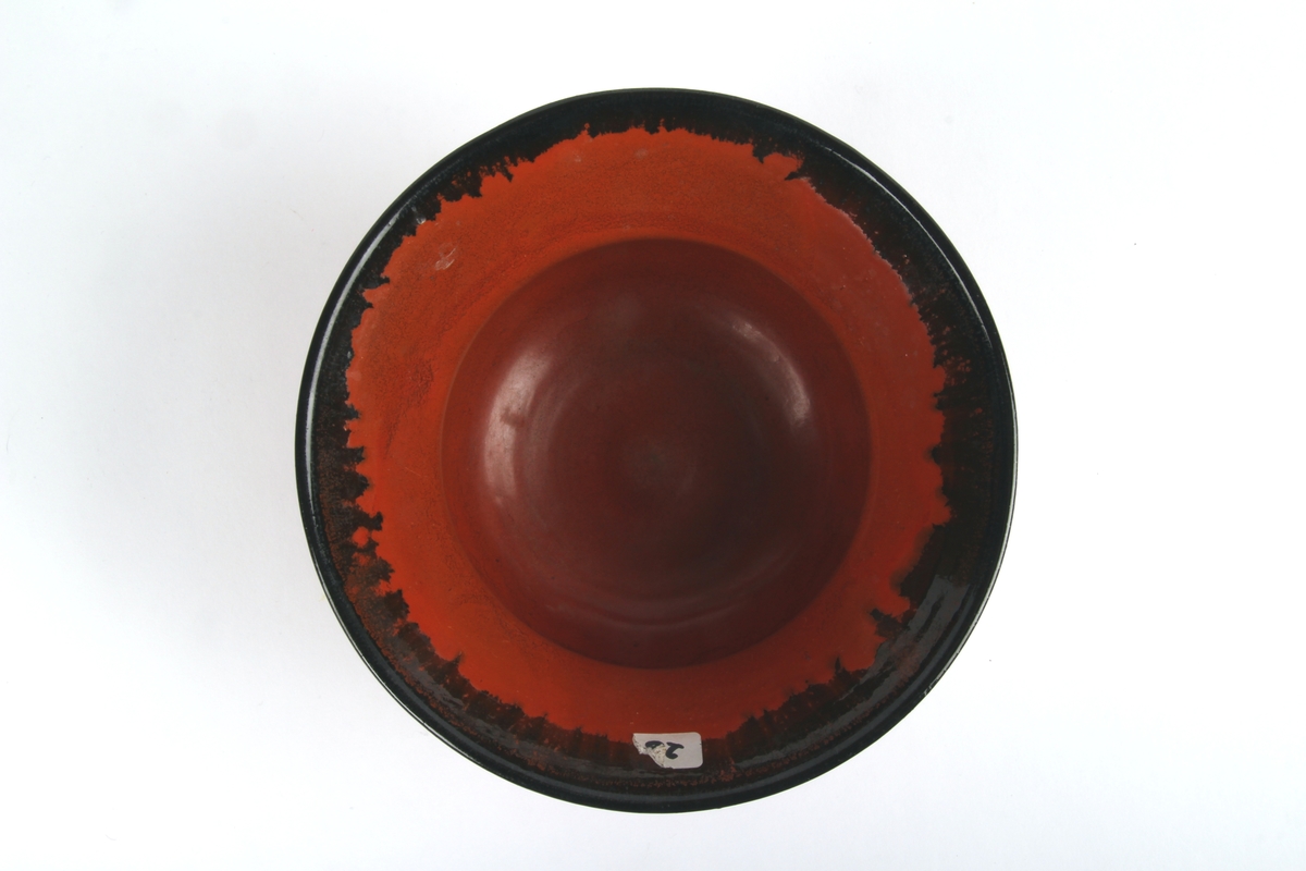 Uranrød potteskjuler med sort glasurkant.