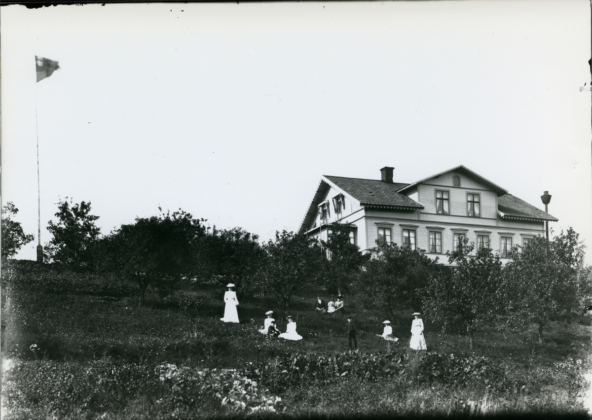 Möklinta sn, Sala.
Tio personer i trädgården utanför bostad innehållande telefonväxeln i Möklinta. C:a 1900.