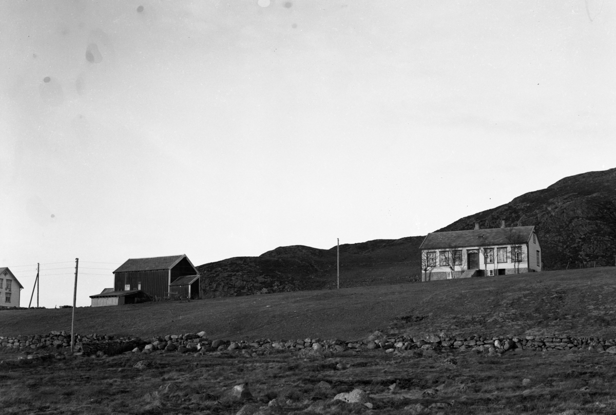 Prospektfotografi av et skolehus. Et av de eldste i Borgund. Tilhørte Giske etter 1907. Til venstre er et gårdsbruk.