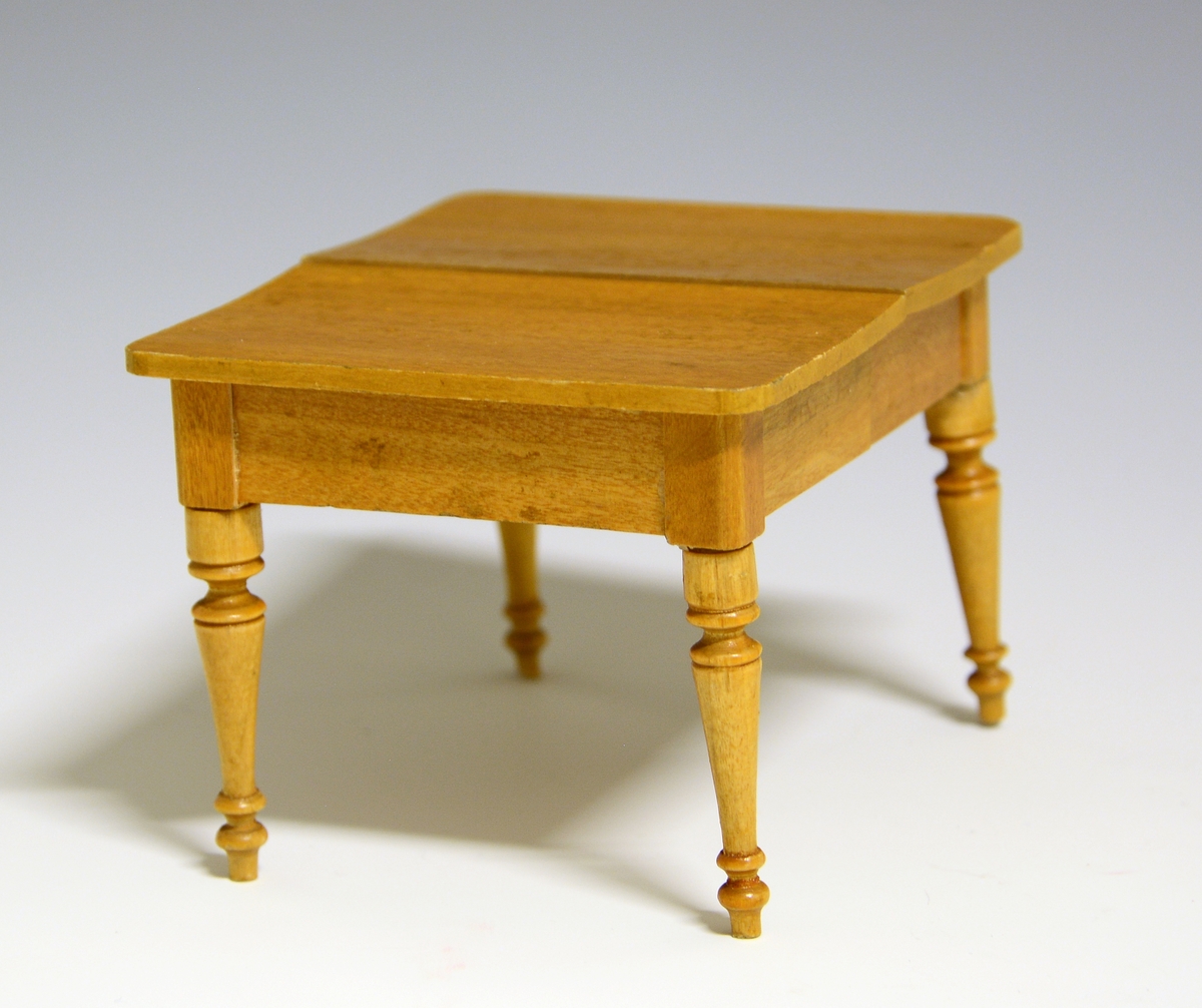 Prot: Bord (Dukkestue-) Utskåret i treplate, dreide ben. Lakkert. Bordet er uttrekssbord.