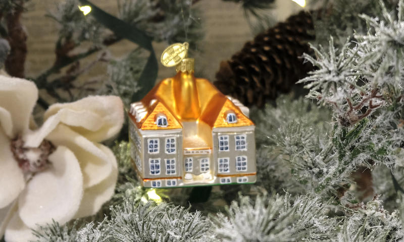 Nærbilde av ei julekule forma som Eidsvollsbygningen, henger på et juletre
