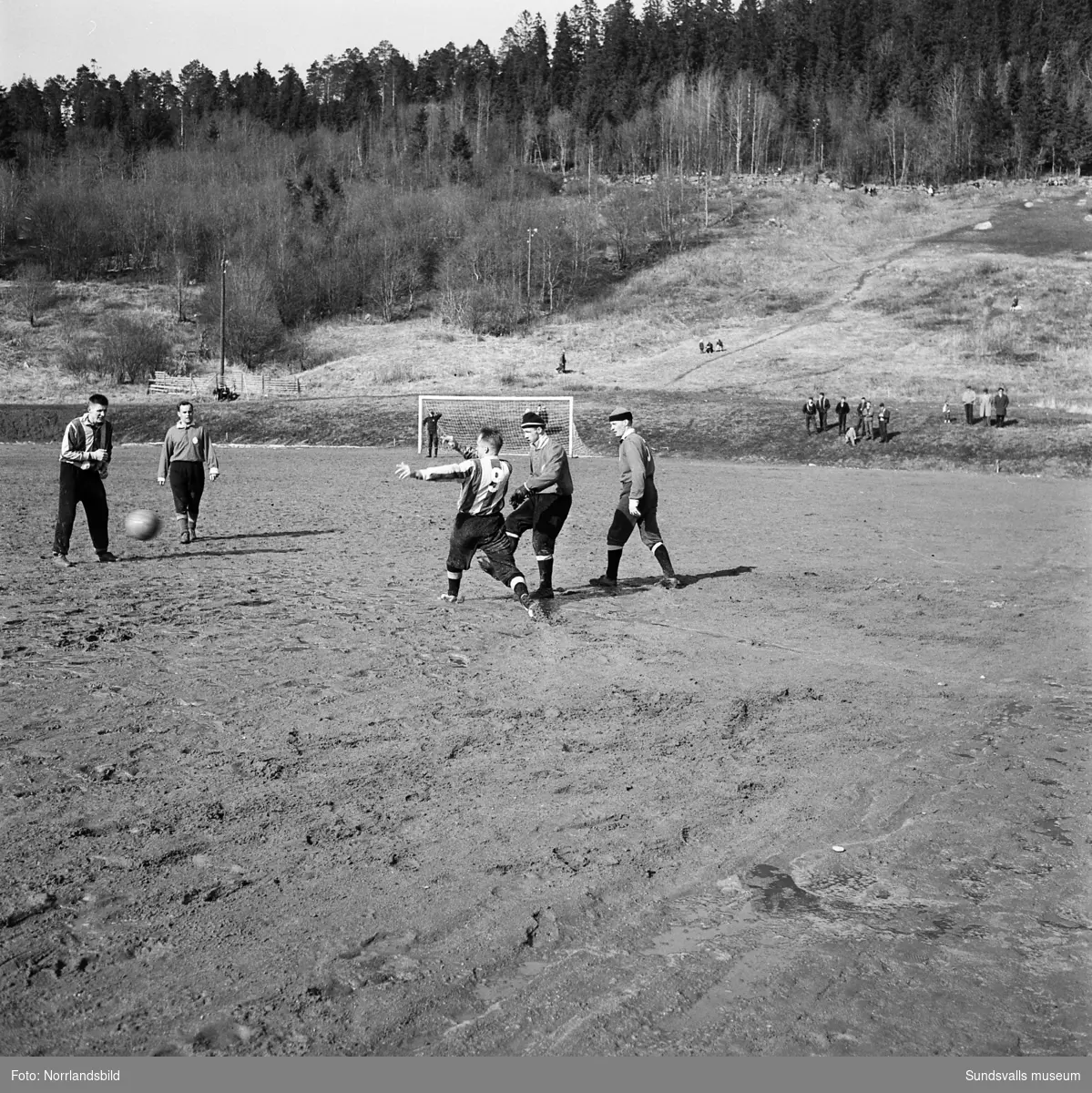 Fotbollsmatch på en lerig Västhagenplan i början av april 1960. GIF Sundsvall vann med 4-1 över Kubikenborg.