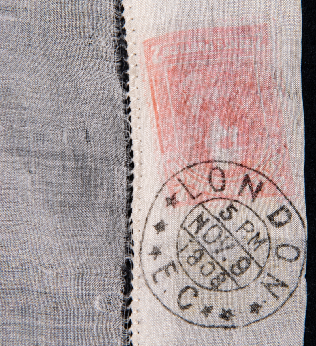 Näsduk av vitt sidentyg med handsydd fåll. Fållen försedd med avbildningar av frimärken samt poststämplar.