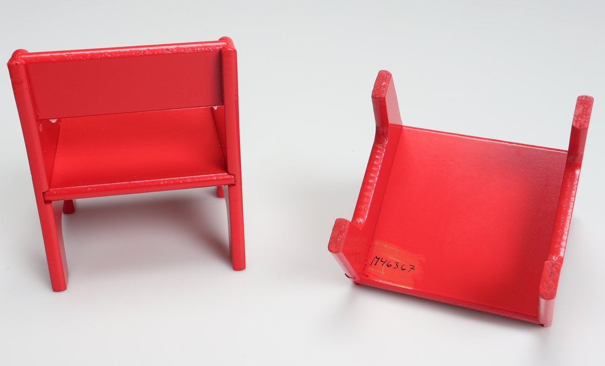 Två rödlackerade stolar (dockmöbel) tillverkade av träfiberskiva. De består av fyra delar sidostycken, sits och ryggbräde. Sidostyckena har en svängd profil. Stolarna är förpackade i en röd och vit pappkartong med svart text på svenska, tyska, engelska och franska.

Inskrivet i huvudkatalog 1982.