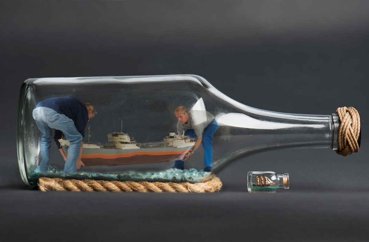 Sjöhistoriska museets modellbyggare Jan Claesson och Stefan Bruhn med en flaskskeppsmodell. Bearbetad bild.