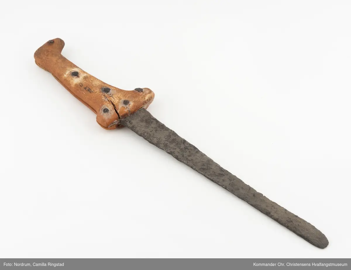 Kniv fra Vest Grønland. Jernblad, beinskaft i to deler, satt sammen med jernnagler.