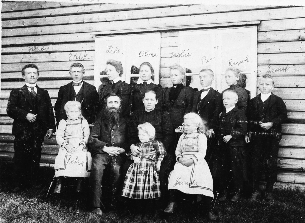 Bonde Per Sørenson Håland og kona Justina Eriksdtr. Sæland med 12 barn.
Bak f. v. : Søren (1876 - 1941), Erik (1877 - 1946),Anne Elisabeth (1879 - 1908), Olina (1881 - ), Justina (1882 - ), Per (1884 - 1951), Ragnhild Elvine (1886 - 1920), Sem (1889 - ), Ernst (1888 - ).
Framme f. v. :Petra Jakobine (1891 - ), far Per Håland (1852 - 1900), mor Justina f, Sæland (1856 - ), Selma (1894 - ), Gunda (1893 - ).
Per Sørenson Håland var bonde på Høga-Håland frå 1881. Han døydde av tæring eit halvt år etter at biletet var teke., 48 år gamal.