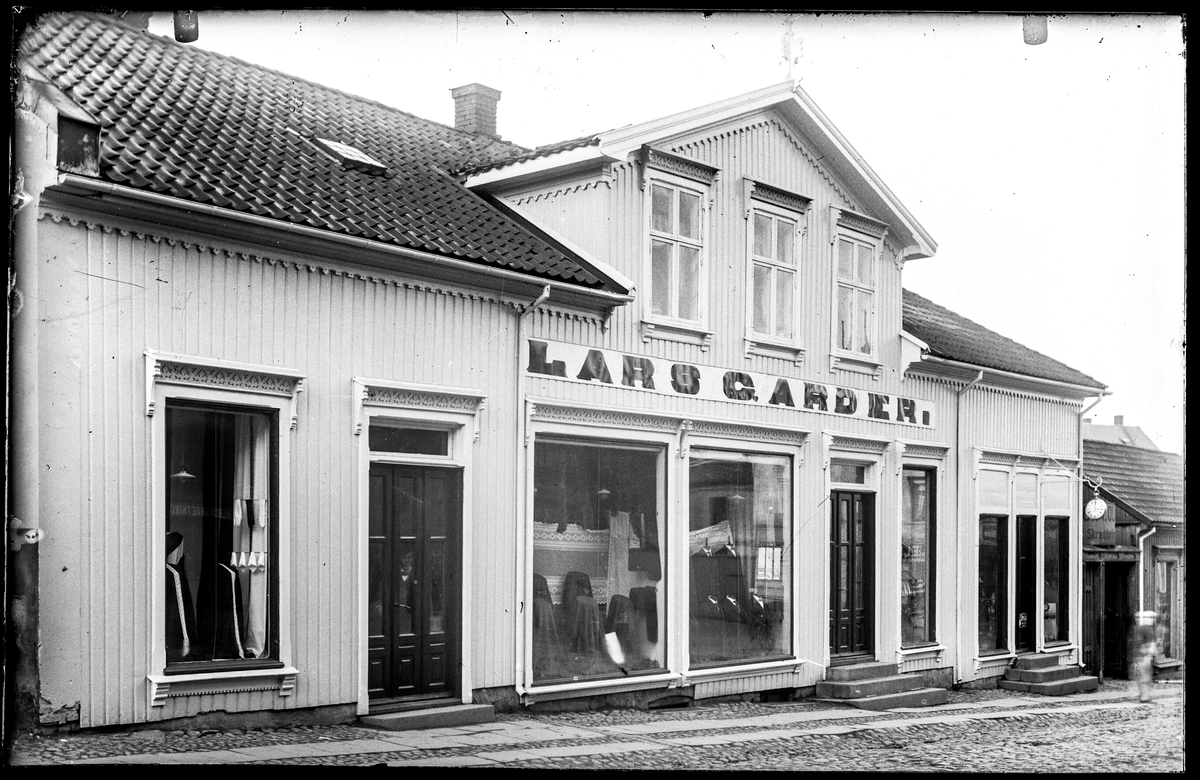 Kongens gate 17 i Moss. Manufakturforretninga til Lars Garder,  f. 1880 fra Kongsberg, kjøpmann (folketellinga Moss 1914), seinere L. P. Sterud. 
I nabohuset til høyre skilt for skredder (utydelig navn, etternavn starter på O. ... Ol....), antakelig O. M. Olsen. 
Urmakerforretning i midten, urmaker Carl Andresen, og skredder O. M. Olsen har gateadresse Vincent Buddes gate 1 i Adressebok for Fredrikshald, Fredrikstad, Moss, Sarpsborg 1911-12.
Forretninga til Lars Garder fins ikke i Adressebok for Fredrikshald, Fredrikstad, Moss, Sarpsborg 1911-12.
Annonse i Moss Tilskuer 16. januar 1915: Restbeholdning av vinterfrakker mm. Altså var butikken i aktivitet i 1914, og Lars Garder annonserte sammen med L. Sterud i 1918.