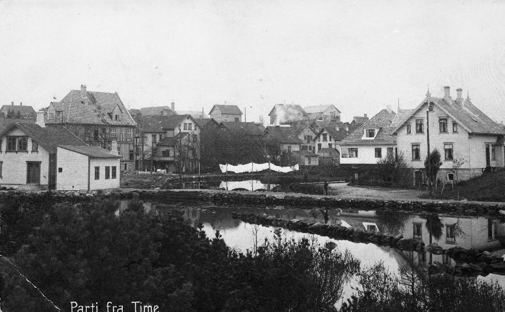 Frå Bryne sentrum med Åno i 1922. Biletet er teke frå området ved Jæren Uldvarefabrikk mot vest. Hus nr. 2 frå høgre er Gjesteheimen. Til venstre er S. Tjemsland og Bellesen Hotel.