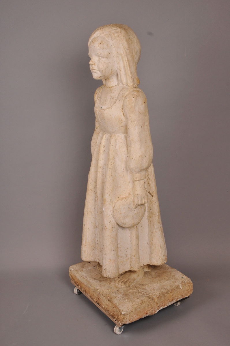 Skulptur, jente med eit brød i handa.