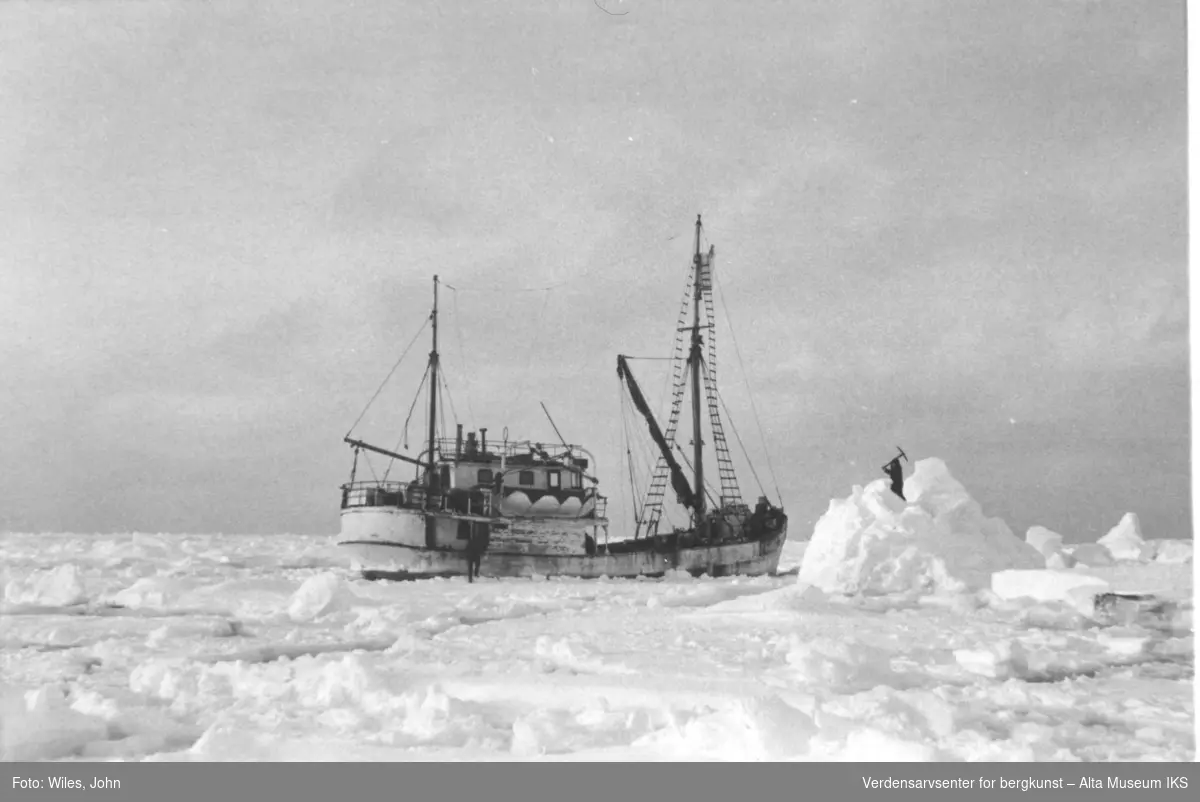 Ferskvannshenting ute på isen. En mann står på ett isberg å hugger løs.