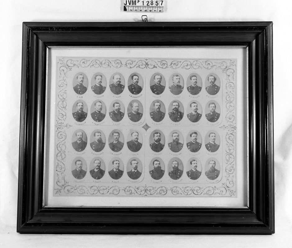 Tavla med porträttsamling eller kollage, i glasad brun träram. Porträtten är ovala och visar Överkonduktör och konduktörer som reste norrut från Centralstationen 1872-1882