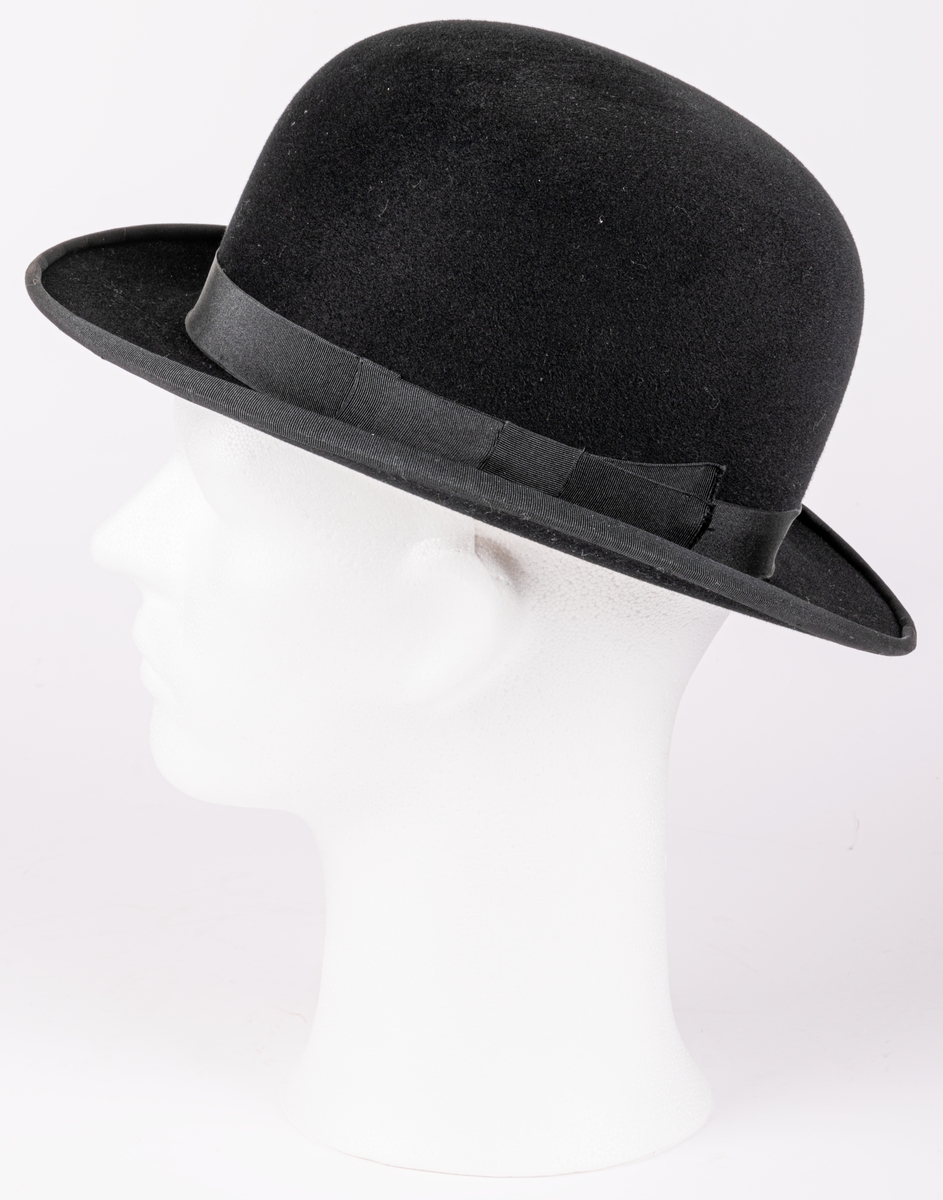 Kubb klädd med svat filt, Märkt: Perfect. Engelska Hattmagasinet Gefle Import.
Tillhörande hattask i brunt läder.