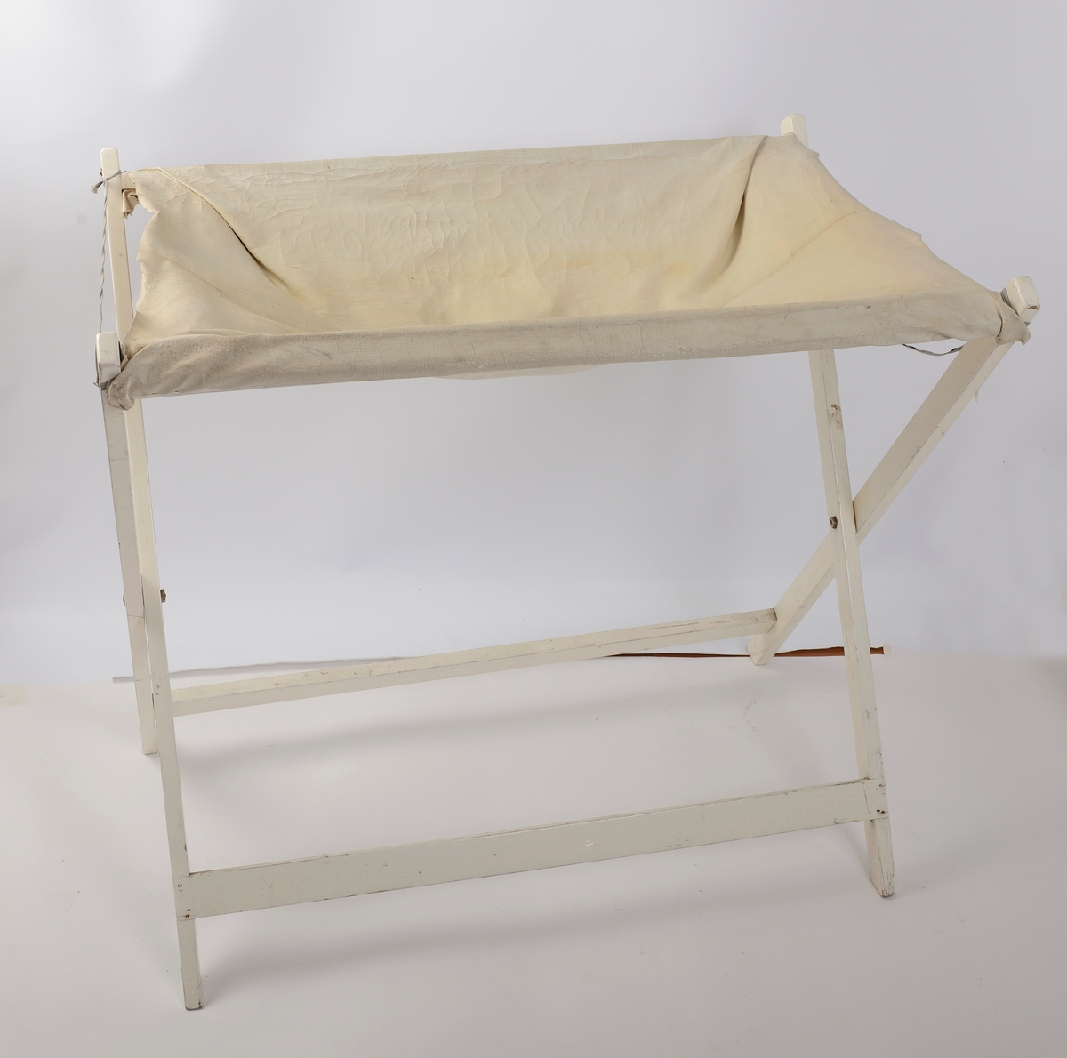 Hvitt stellebord i tre, gummiert stoff med tilhørende badekar til baby.