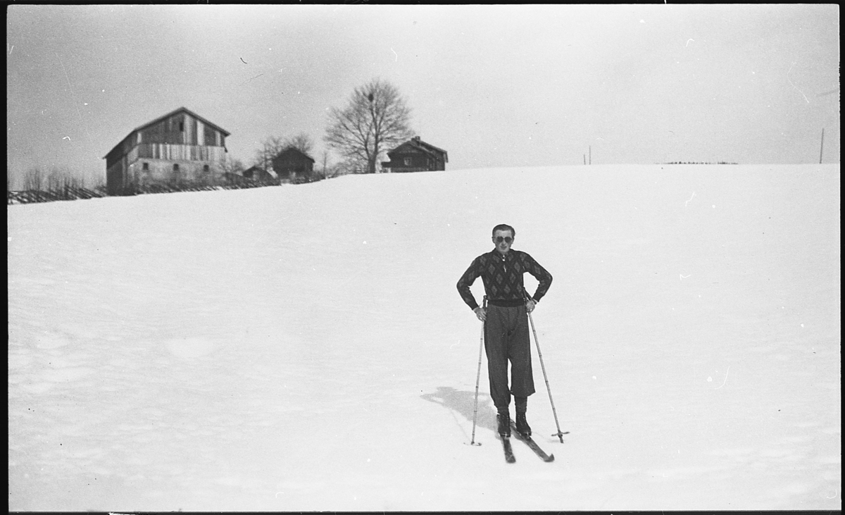 Gunvald Albjerk på ski, ca. 1935. I bakgrunnen den tidligere bebyggelsen på Vestre Blegeberg.